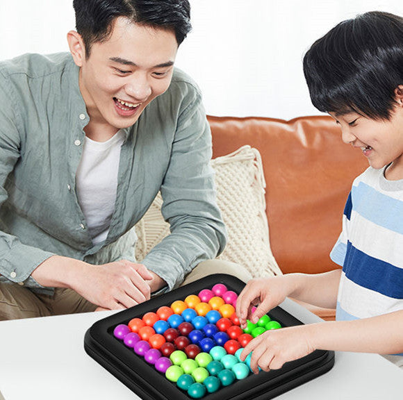 Father and son playing the colorful Beads Brainstorming Game from Arts And More on a white table