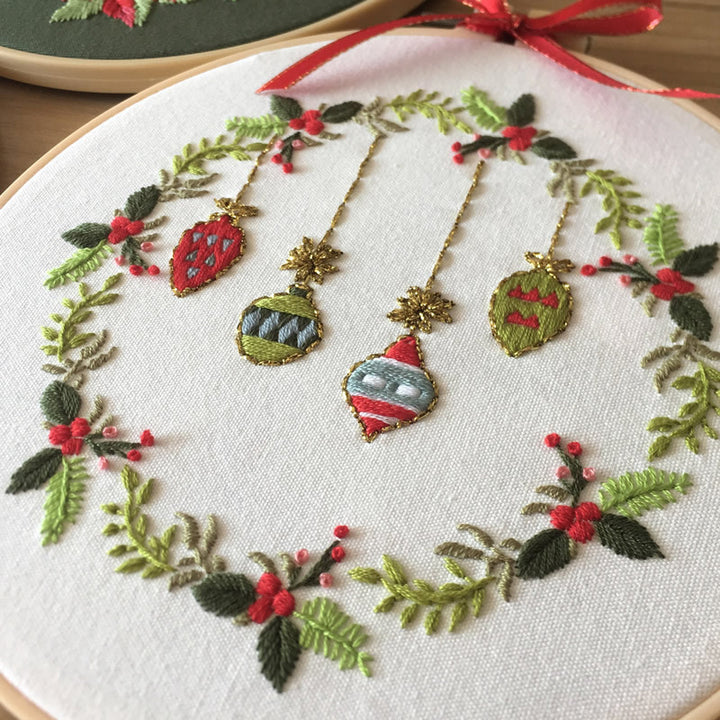Arts And More Cross Stitch Kit featuring decorative holiday ornaments and greenery on fabric