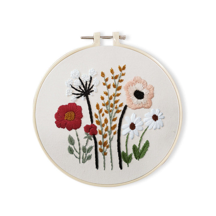 Dainty Stems Embroidery Kit featuring colorful floral designs in a wooden hoop