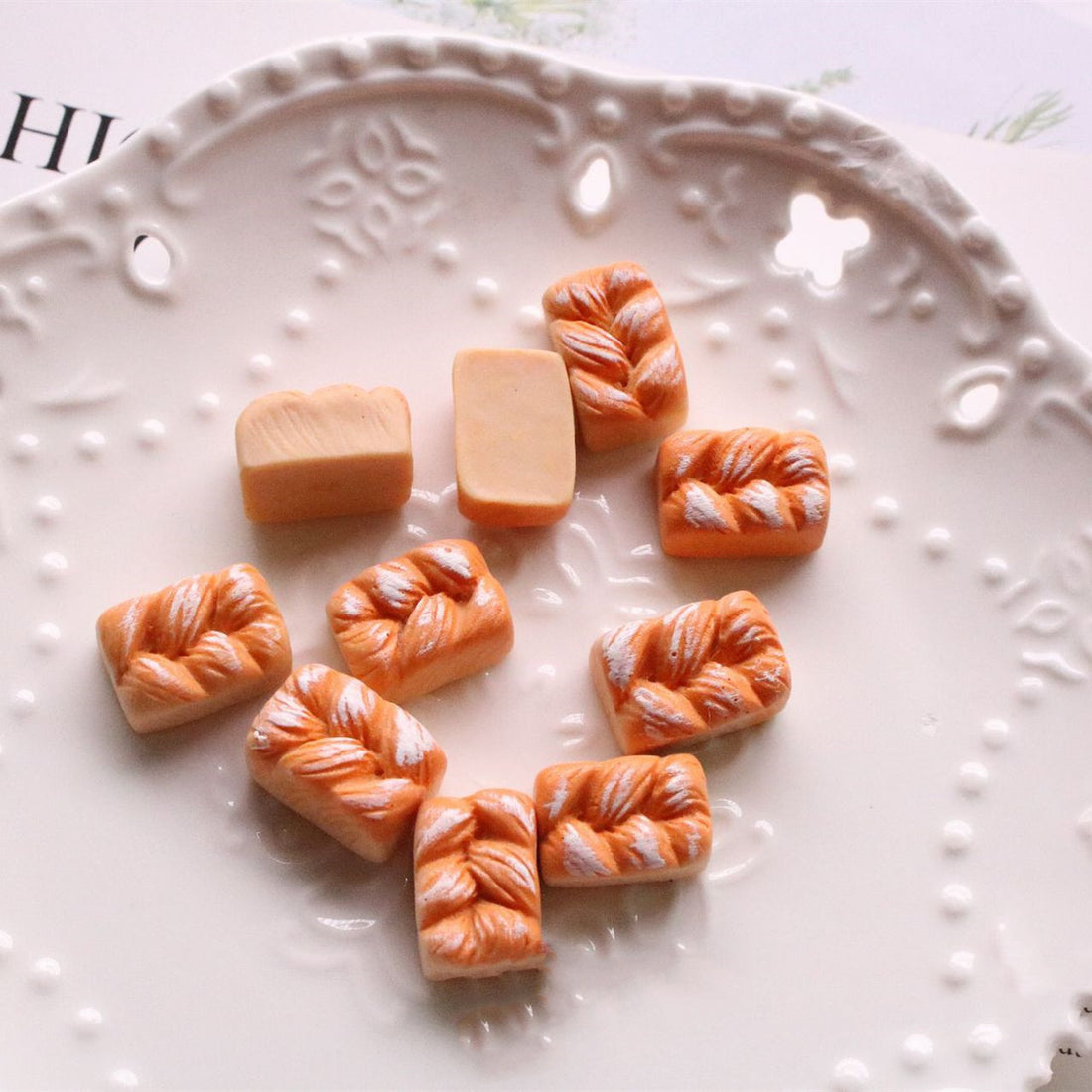 Arts And More jewelry accessories kit with small polymer clay bread charms on decorative white plate