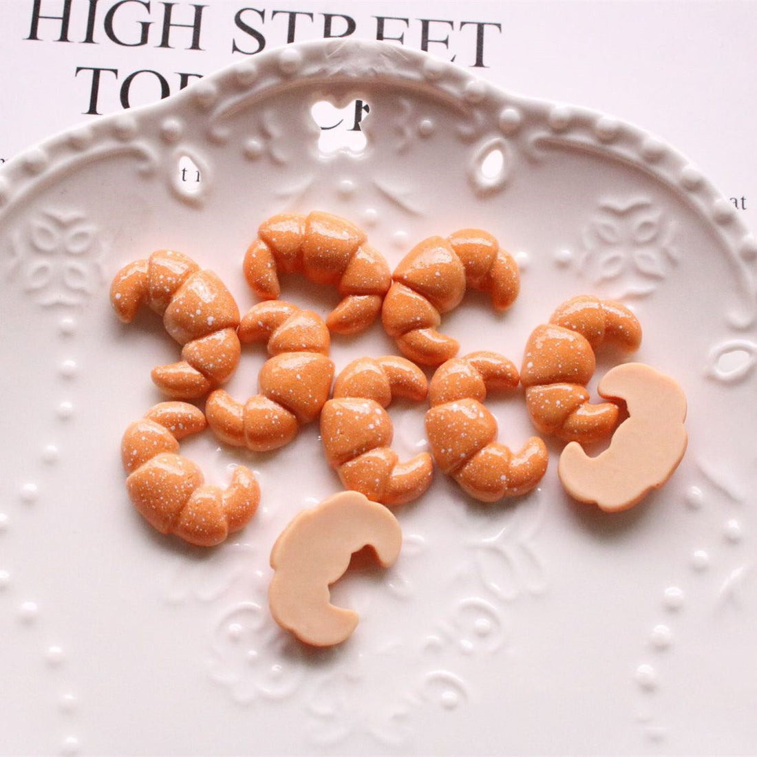 Arts And More Jewelry Accessories Kit with miniature croissant-shaped craft materials on a decorative plate