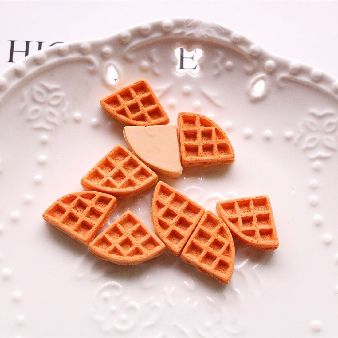 Arts And More craft materials featuring waffle-shaped pieces from Jewelry Accessories Kit on a decorative white plate