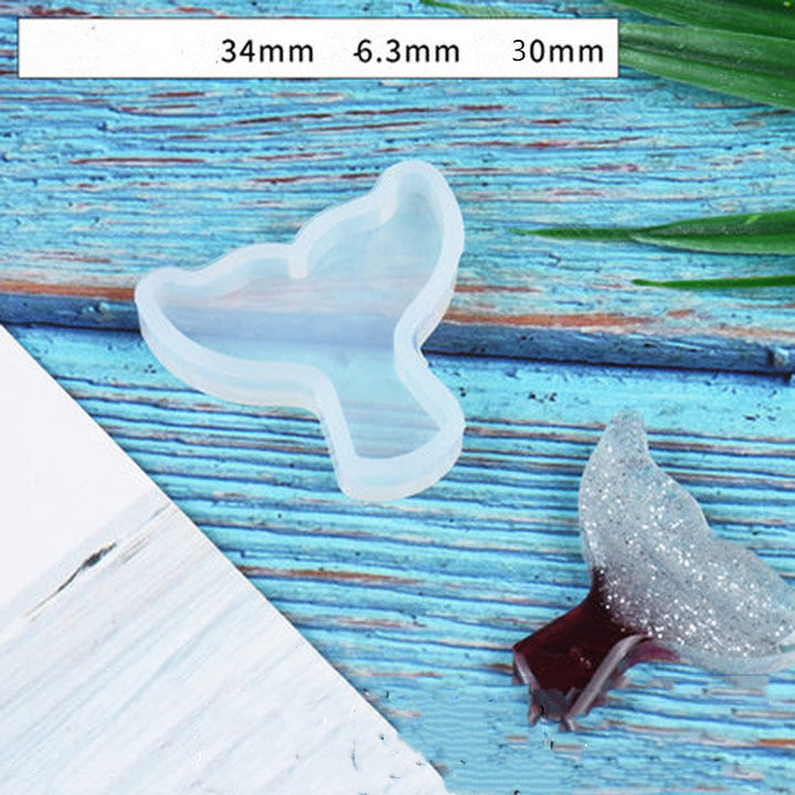 Clear Tail Silicone Mold for crafting resin or clay projects by Arts And More on a blue wooden surface