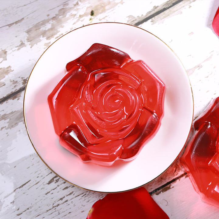 Arts And More Rose Oil Soap shaped like a red translucent rose on a white plate
