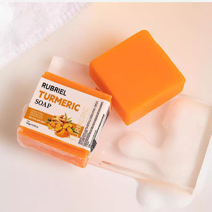 Arts And More turmeric soap bar with bright orange color and packaging on a white tray with foam