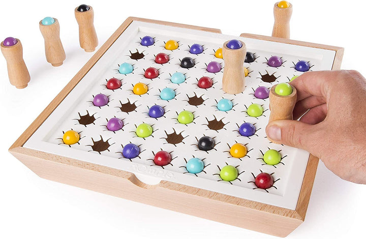 Arts And More Marble Stomping Game wooden board with colorful marbles and hand placing a peg