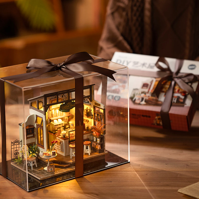 Cafe Miniature House Kit displayed in a clear box, beautifully crafted with intricate details and decorations