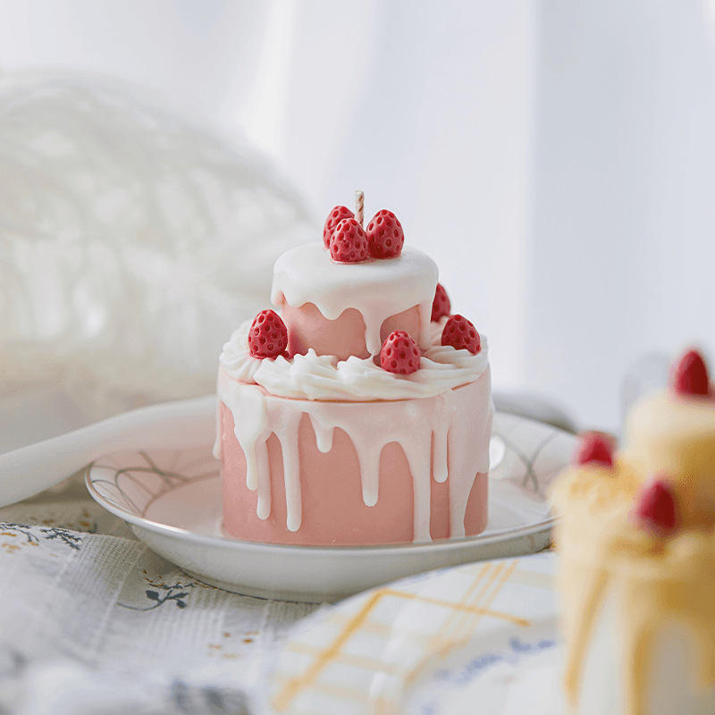 Elegant pink birthday cake with frosting and strawberries topped with a cake birthday candle