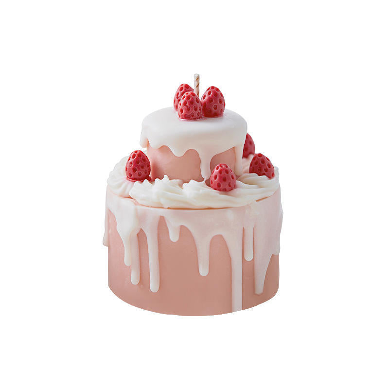 Decorative pink cake with frosting and strawberries topped with a cake birthday candle