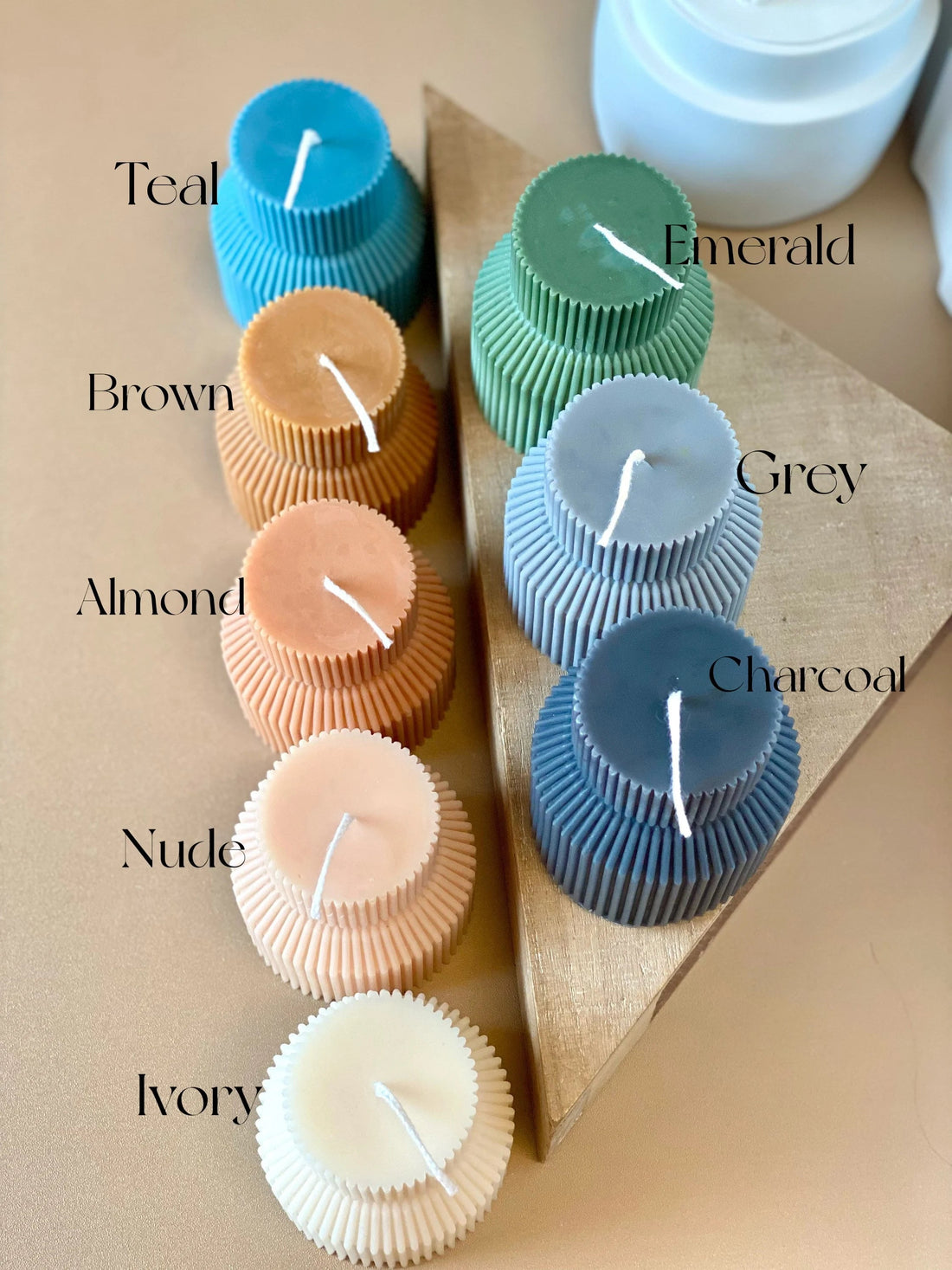 Colorful cat candles in teal, emerald, brown, and more, arranged with a triangular holder for decorative display