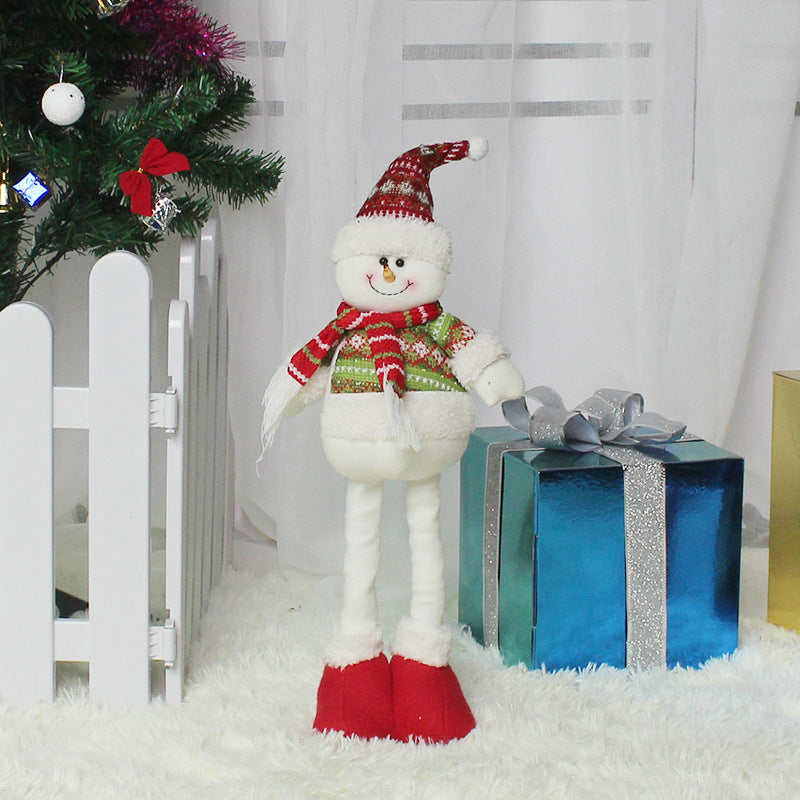 Christmas decorations featuring a plush snowman with a festive scarf and hat standing by a Christmas tree
