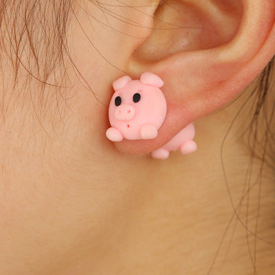 Pink pig shaped clay animal earrings worn on ear by Arts And More, cute handmade decoration accessory