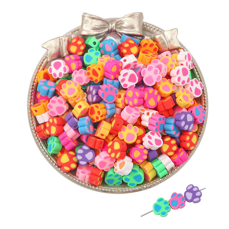 Colorful clay beads with paw print designs by Arts And More in a silver decorative bowl
