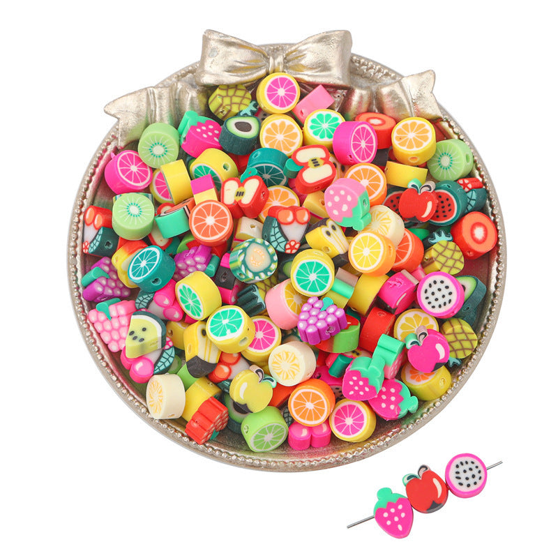 Colorful fruit-themed clay beads in a decorative dish for crafting and jewelry making
