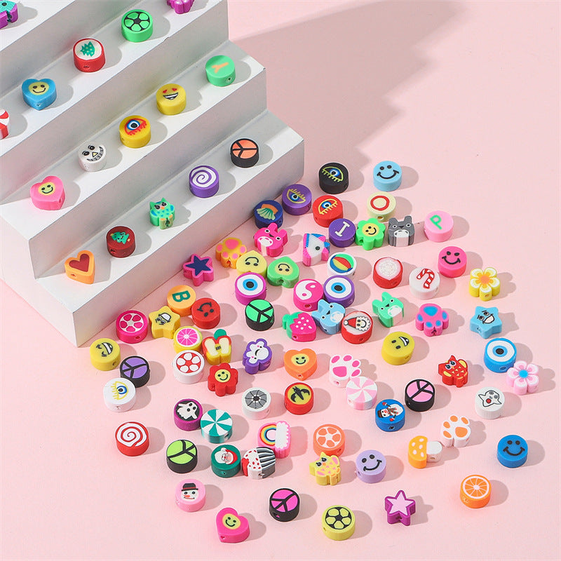 Colorful Arts And More clay beads in various shapes and designs displayed on white steps and pink surface