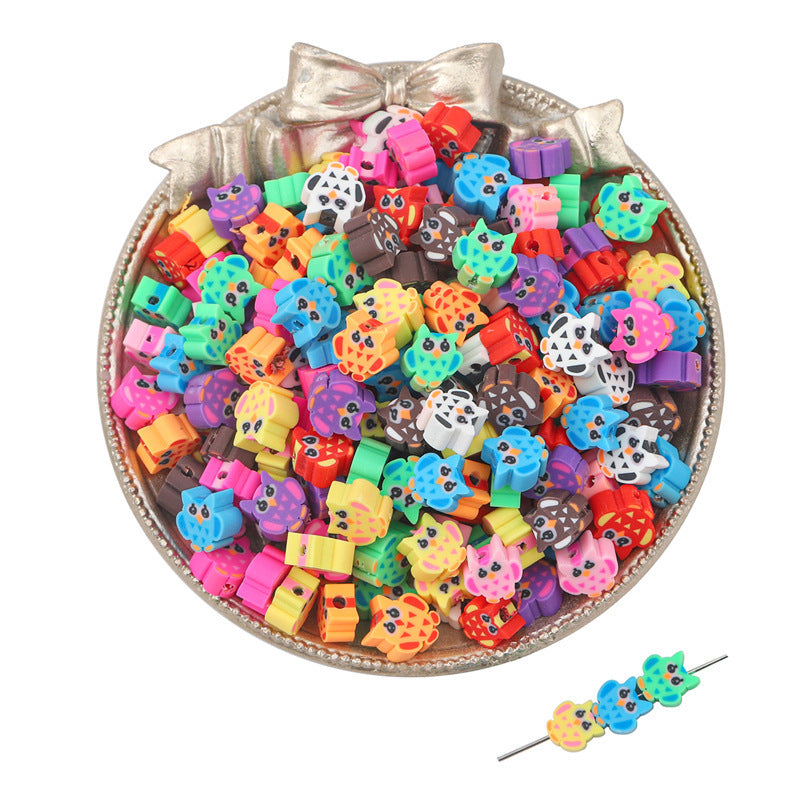 Assorted colorful owl-shaped clay beads in a decorative silver bowl for craft projects