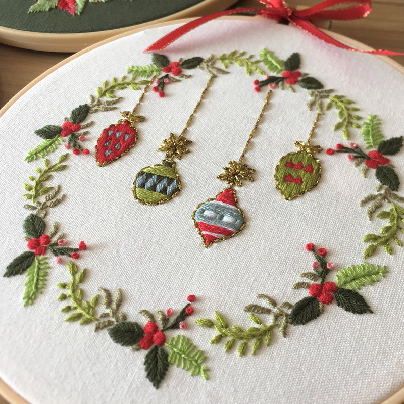 Arts And More Cross Stitch Kit featuring decorative holiday ornaments and greenery on fabric