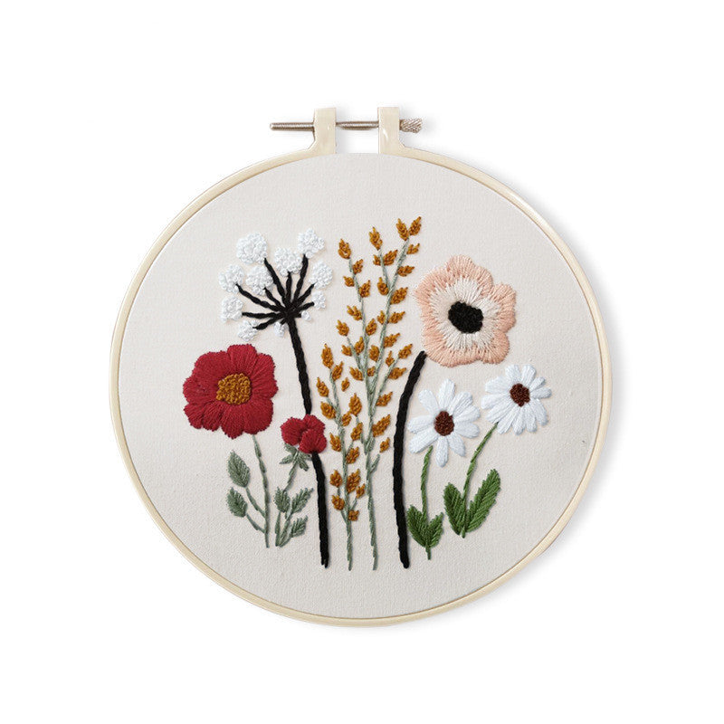 Dainty Stems Embroidery Kit featuring colorful floral designs in a wooden hoop