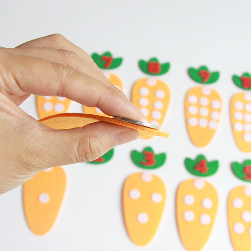 Hand placing a coin on orange felt carrot piece from Arts And More Kids DIY Kits Educational Matching Toy