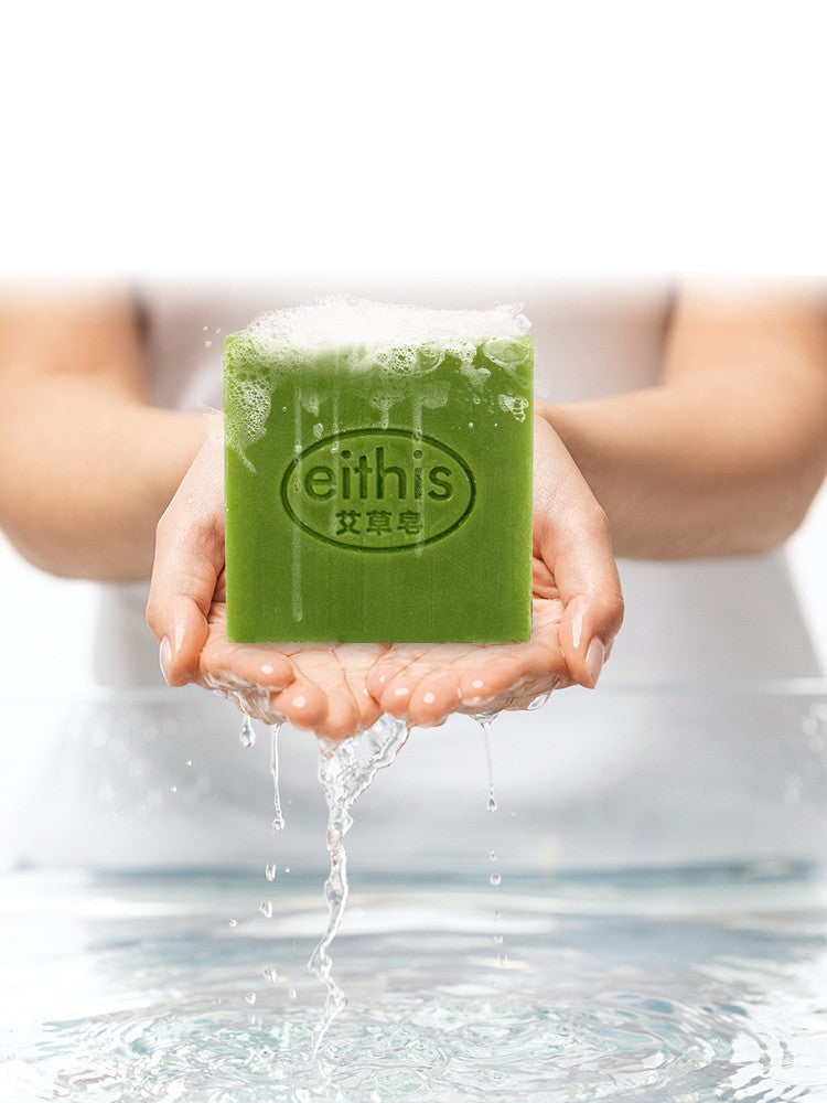 Green Arts And More Bath Soap bar with water drops held in hands over a water surface