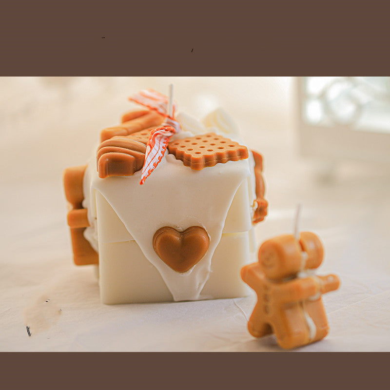 Gingerbread Candles in festive designs with decorative cookies and a cheerful gingerbread man