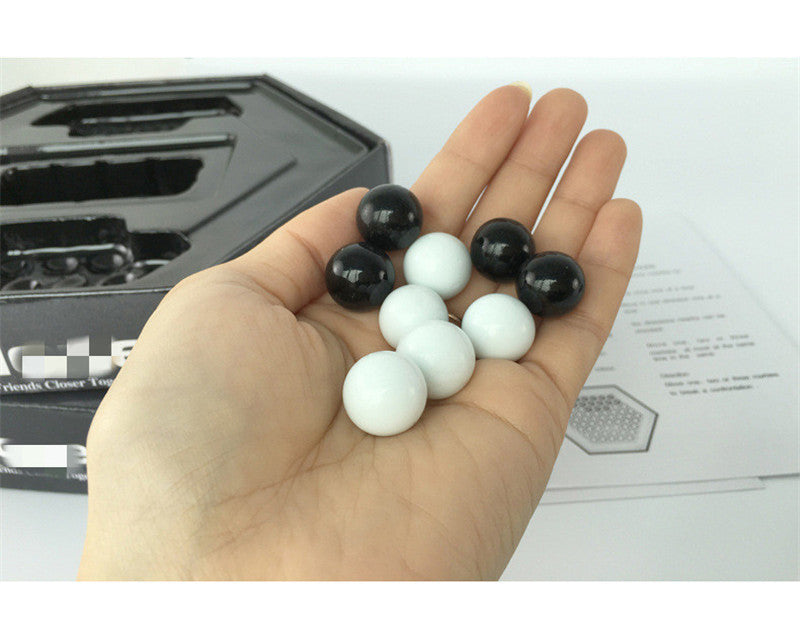 Hand holding black and white marbles for Hercules Puzzle arts and crafts kit by Arts And More