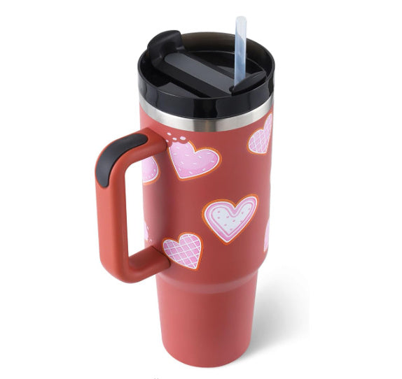 Arts And More insulated tumbler with handle in red featuring pink heart designs and black lid with straw