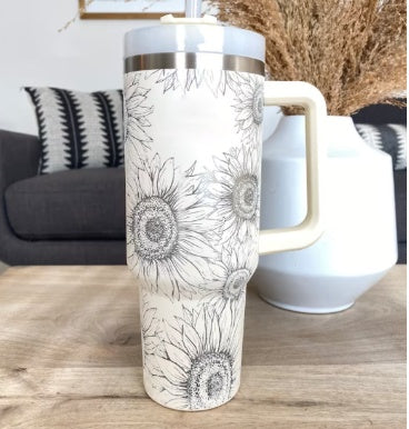 Arts And More insulated tumbler with handle featuring black and white sunflower design on a wooden table