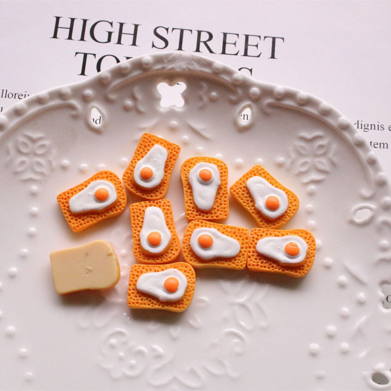 Arts And More Jewelry Accessories Kit with small orange and white egg-shaped craft materials on decorative plate