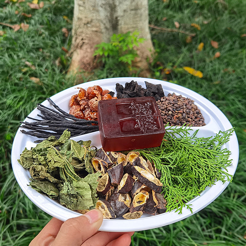 Arts And More Anti-Hair Loss Soap placed on a plate with assorted natural herbs and plants