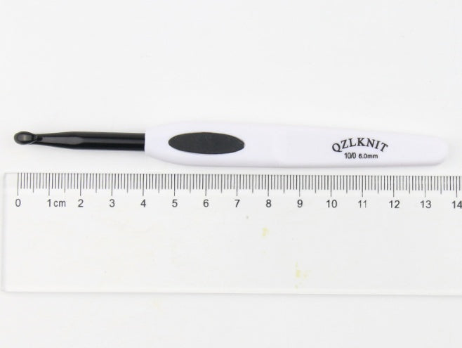 Arts And More aluminum crochet hook with ergonomic white handle and black tip measuring 6mm