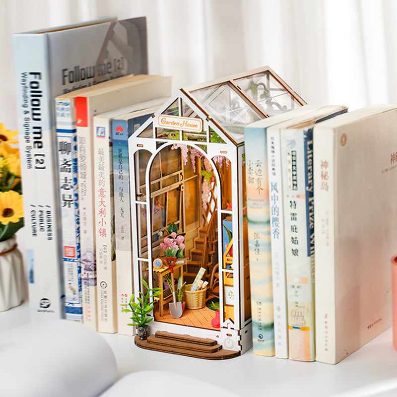 Rolife Garden House Book Nook Kit displayed among books, showcasing intricate design and vibrant colors