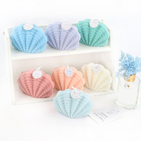 Colorful seashell candles displayed with a seashell candle mold for crafting projects