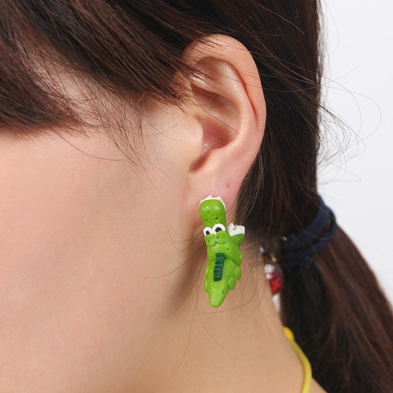 Green soft clay earrings shaped like a crocodile worn on ear for unique decorations