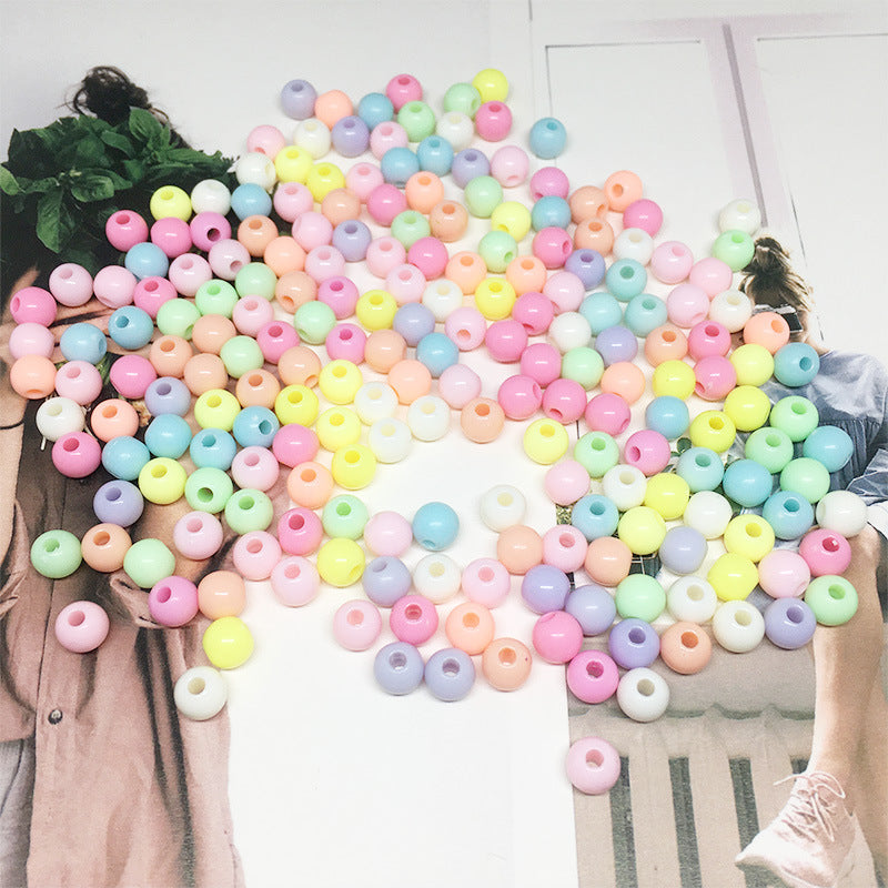 Colorful pastel Acrylic Round Beads scattered over photo background from Arts And More craft materials