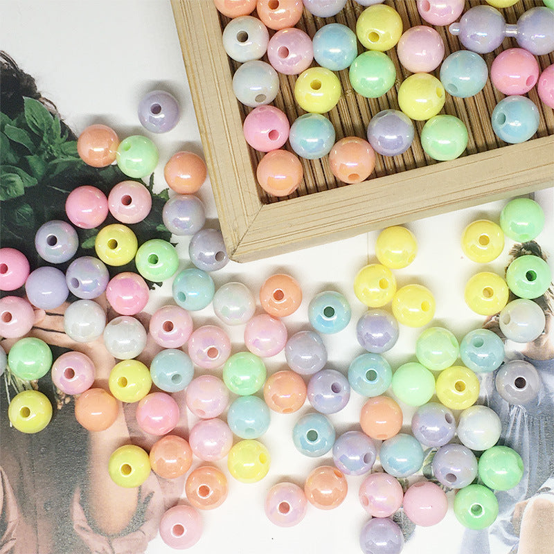 Colorful pastel Acrylic Round Beads scattered and arranged in a wooden tray for crafting