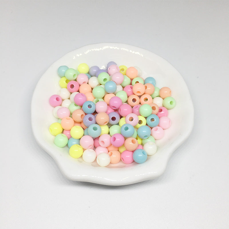 Arts And More colorful Acrylic Round Beads in pastel shades on a white ceramic dish for craft projects