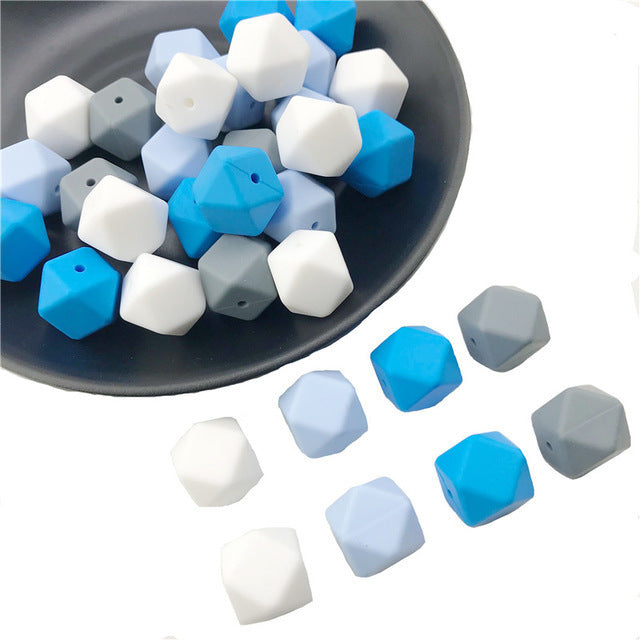 Arts And More hexagon beads in blue white gray colors arranged on black plate and white background