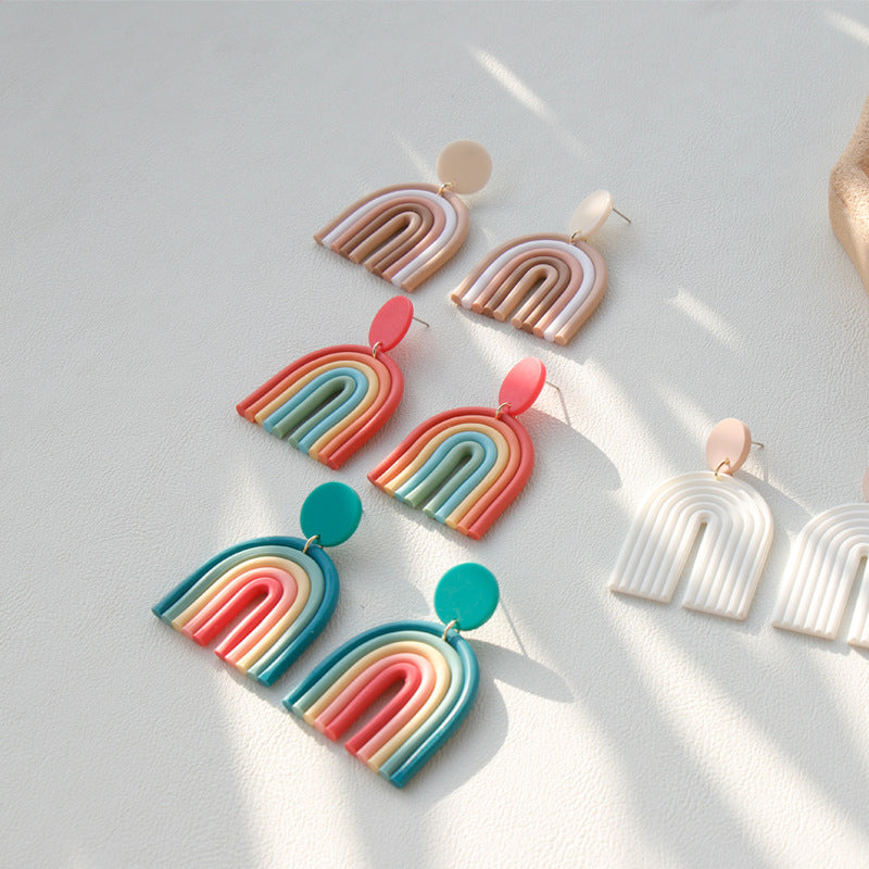 Colorful Rainbow Polymer Clay Earrings in multiple pastel and bright shades laid out on a white surface