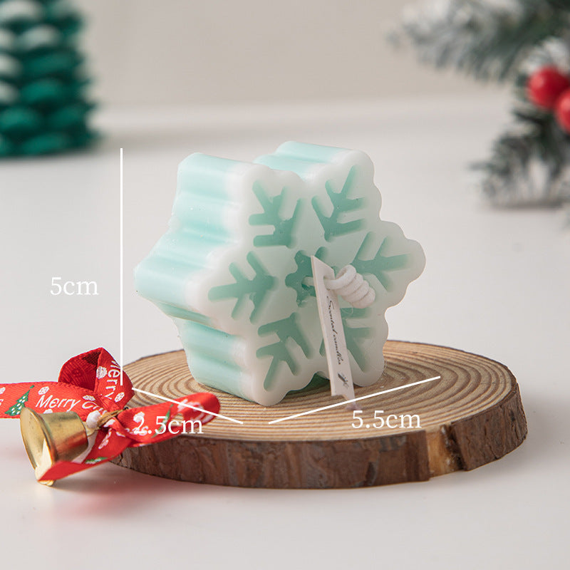 Snowflake Aromatherapy Candle in light blue atop a wooden slice, perfect for winter decor